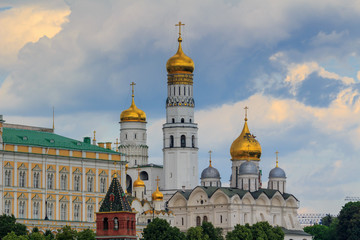 Fototapeta na wymiar Cathedral of the Archangel and Ivan the Great Bell-Tower on the territory of Moscow Kremlin against cloudy sky