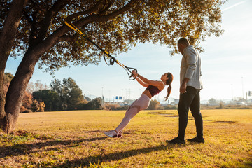 Personal trainer training a girl on the outside