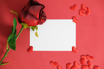 empty white love card with rose on red texture background.