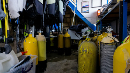 Scuba diving gear storage with many oxygen yellow tanks in an old store
