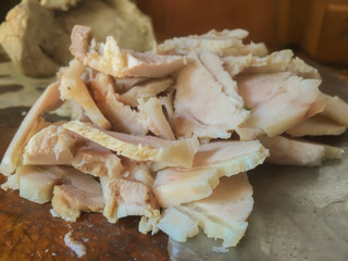 closeup of traditional cooked pork slide on wood with knife