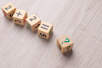Wooden cubes with numbers. Teaching a child of preschool age mathematics. question mark. child...