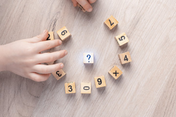 Wooden cubes with numbers. Teaching a child of preschool age mathematics. question mark. child...