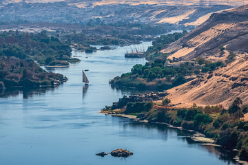 Sunset over the Nile River in the city of Aswan with sandy and deserted shores - obrazy, fototapety, plakaty