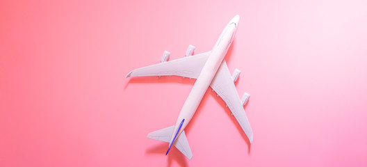 Model plane, top view of airplane on pink color background. travel planning concept