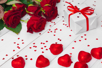 St. Valentines Day. Red roses and gift box on wooden table