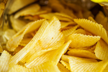Potato chips in open snack bag close up