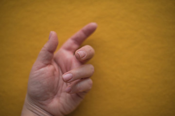 woman hand on the mustard wool fabric textile background