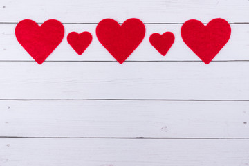 White Saint Valentine's day background with red hearts lined at the top, copy space