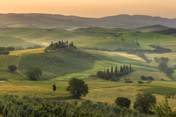 Tuscany Toscana landscape at sunrise with traditional farm house, hills and meadow. Val d'orcia, Italy.	