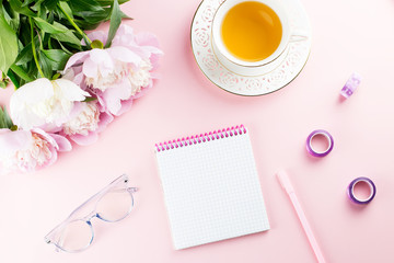 Beautiful cosmetics and flowers flat lay with note book, herbal tea on pastel background.