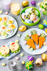 Funny colorful Easter food for kids with decorations on table. Easter dinner concept