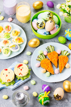 Naklejki Funny colorful Easter food for kids with decorations on table. Easter dinner concept