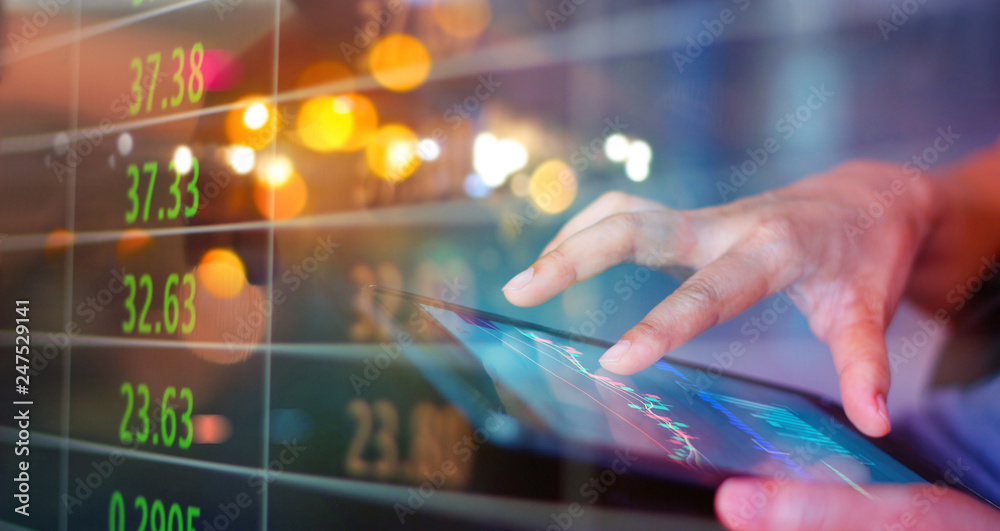 Poster businessman using tablet at night timestock market. businessman using a mobile device to check marke