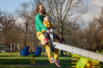 Father and son playing at seesaw in public playground, Zagreb, Croatia.
