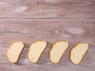 Four pieces of white bread on a brown wooden background