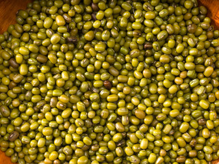 Green gram in bowls over brown background, ingredients for kichary