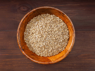 Oats in bowls on a brown background