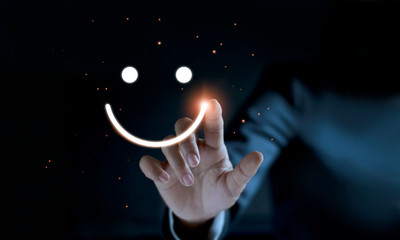 Finger of businessman touching and drawing face emoticon smile on dark background, service mind,...