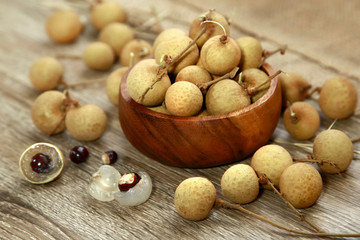 yellow longan fruit on wooden bowl