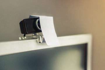 Naklejka premium web camera covered with a sheet of paper, the concept of protection from peony, surveillance. Observation of people, concept.defense from hackers