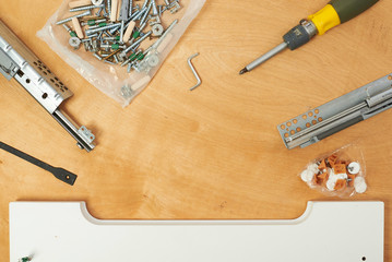 The furniture assembler joins together the two parts of the ready-to-assemble furniture with cam lock connections and wooden dowel pin, flat pack furniture assembly service, snap-together joints