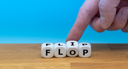 Hand turns a dice and changes the word "FLIP" to "FLOP"