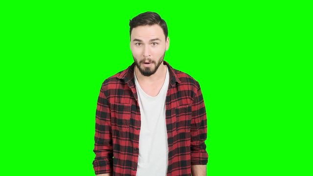Young man showing his thumbs up on green screen, happy smile. White male. For Chroma key.