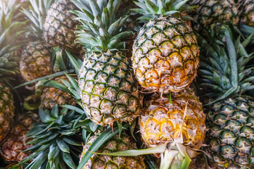 Fresh ripe pineapples at fruit market,tropical fruit juice,diet fruit,vegetarian,high fiber,sweet and sour,blur background