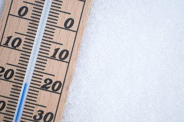 wooden thermometer in snow with freezing temperature copy space