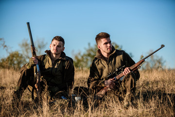 Hunters with rifles relaxing in nature environment. Hunting with friends hobby leisure. Hunters...