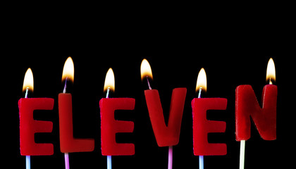 Eleven spellt out in red birthday candles against a black background