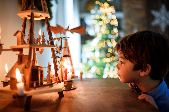 Boy standing in front of a sideboard looking at Christmas decorations