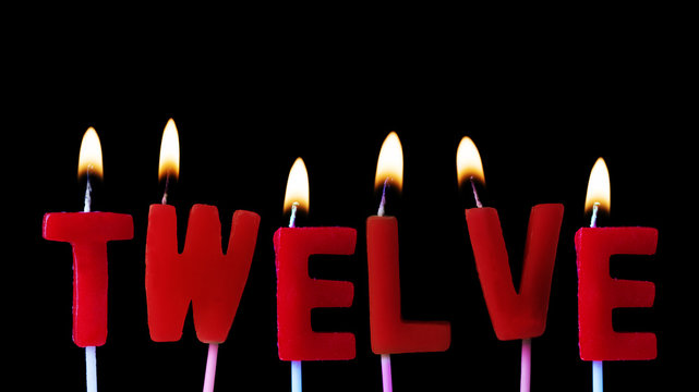 Twelve spellt out in red birthday candles against a black background