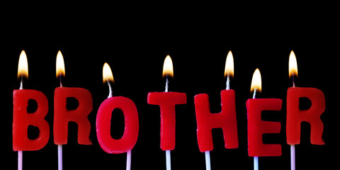 Brother spellt out in red birthday candles against a black background
