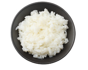 White rice in black bowl isolated on white background. top view