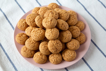 Almond cookies on pink plate, side view.