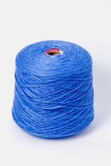 Blue bobbin of yarn on a white background.Textile reel on isolated white background.