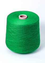 Green bobbin of yarn on a white background.Textile reel on isolated white background.