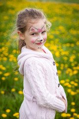 Cute girl in a dandelion meadow