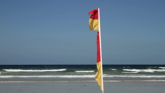 Red and yellow safe bathing area flag, Newquay, Cornwall, England