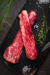 beef tenderloin on a black Board with salt and thyme, bavet steak
