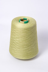 Green bobbin of yarn on a white background.Textile reel on isolated white background.