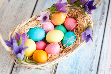 Fototapeta na wymiar Easter eggs in a basket on a wooden table