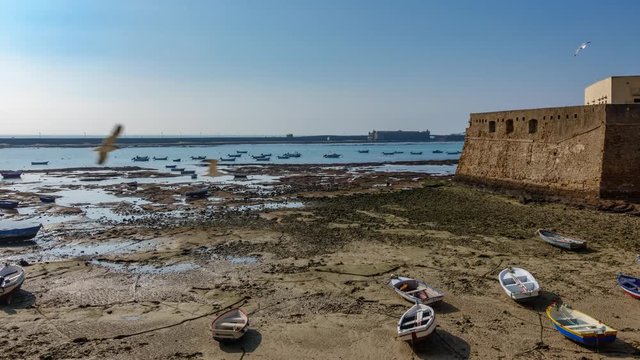 Cadiz fort and boats near beach timelapse