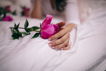woman holding a bouquet of roses in hands of bride and groom