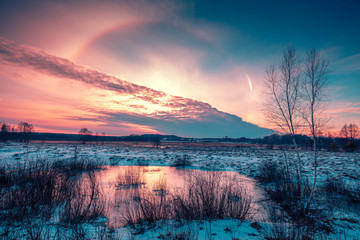 Winter snowy scenery. Snow covered field at sunset