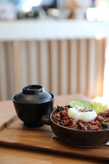 Steak tuna on rice with egg Japanese style on wooden table