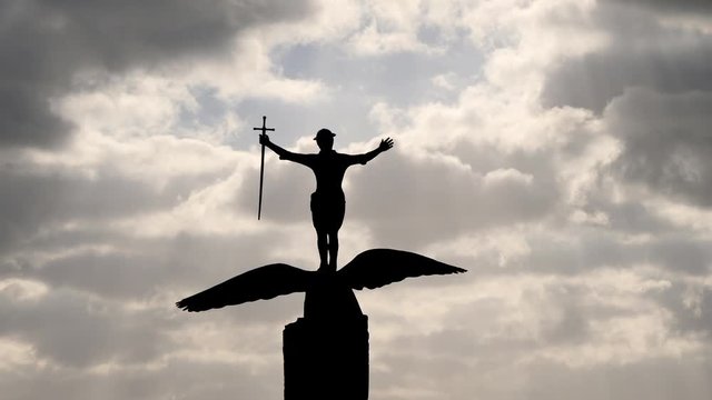 The statue of the Sammy, on the beach of Saint-Nazaire. A monument destroyed and then rebuilt. Filmed against the light. Cloudy sky. There are a rays of light in the sky.