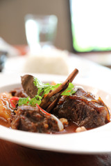 Beef massaman curry with rice and salad on wooden background , Thai food